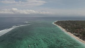 Aerial Drone Shot of Nusa Lembongan wild beach with boats and reef, southeast of Bali, Indonesia. Tropical clear blue turquoise water. White waves, ocean. High quality 4k footage