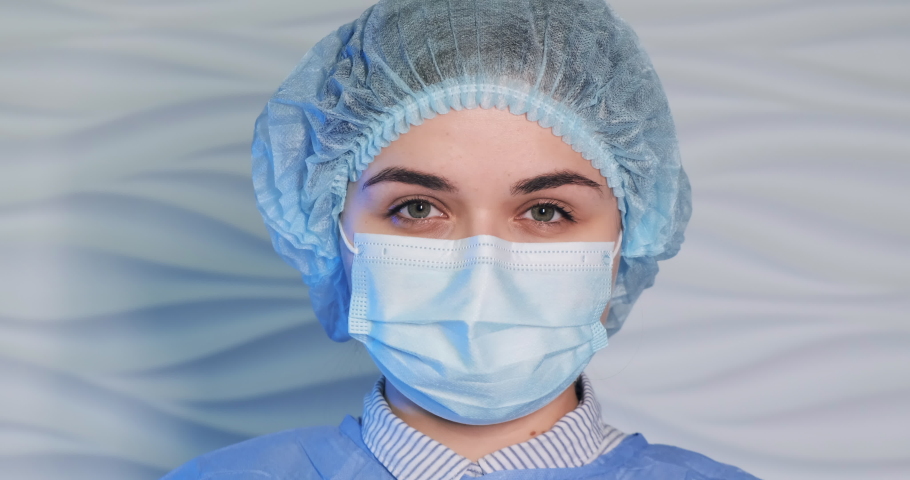 Slow motion portrait close-up high key light shot of microbiologist wearing protective wear glases. Tired medical pharmaceutical workers, laboratory research, doctors hospital. Vaccine research, DNA.