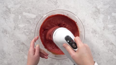 Flat lay. Step by step. Mixing ingredients in a glass mixing bowl to prepare red velvet bundt cake.