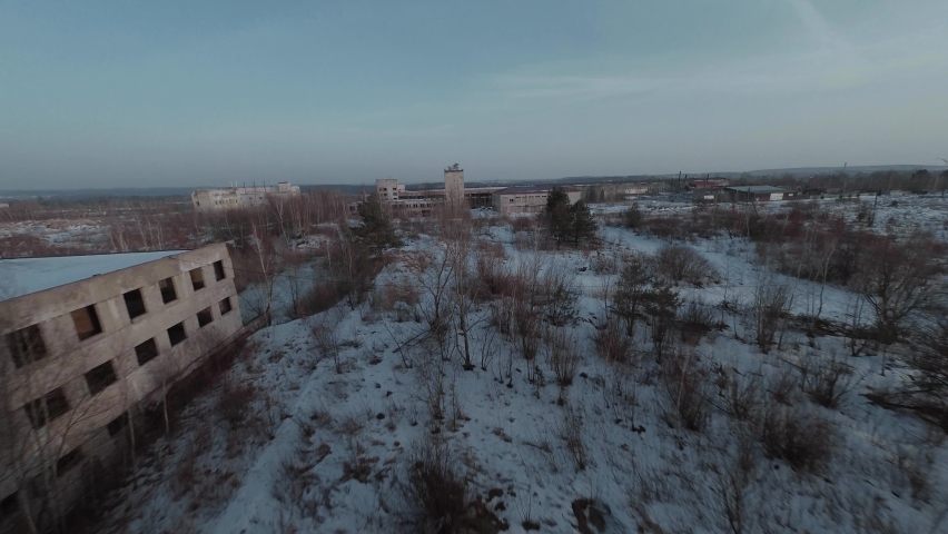 FPV drone quickly flies through an abandoned building and moves away from it