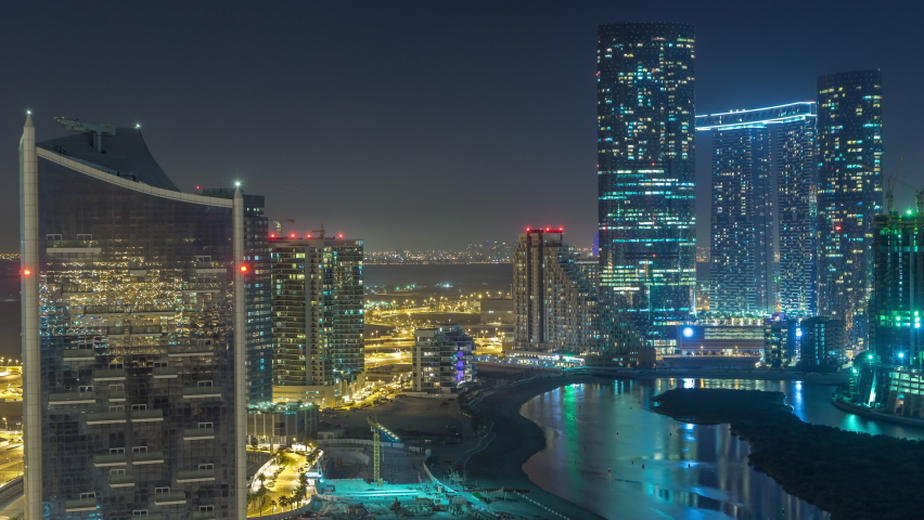 Skyscrapers on Al Reem Island in Abu Dhabi day to night transition timelapse after sunset from above. Aerial citiscape from Al Reem Island with illuminated buildings