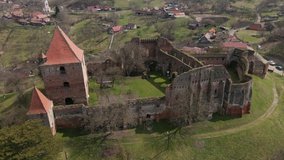 Aerial footage of a medieval fortication ruin shot from a drone while circling around the keep. Video of a medieval keep on top of the hill.