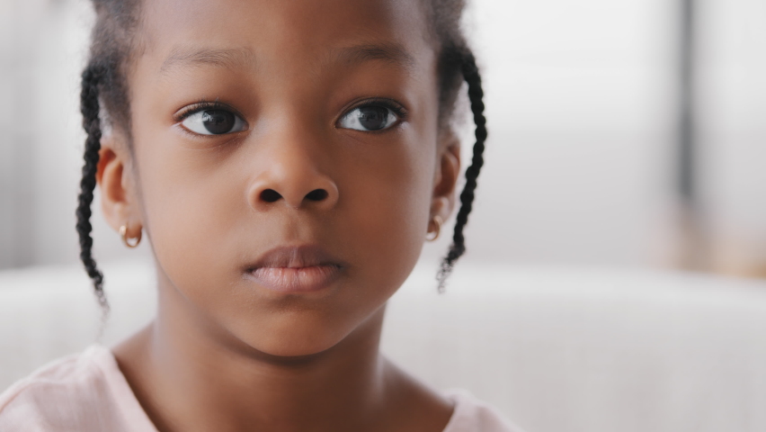 Portrait sad cute african child orphan offended afro american ethnic small girl black mixed race toddler 7 years kid looking at camera upset facial expression suffering from loneliness discrimination Royalty-Free Stock Footage #1071217390