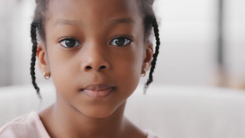 Portrait sad cute african child orphan offended afro american ethnic small girl black mixed race toddler 7 years kid looking at camera upset facial expression suffering from loneliness discrimination