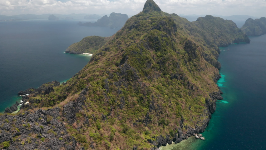 Drone shot going up by Matinloc Island an deserted Island nearby El Nido, Palawan, Pilippines.
