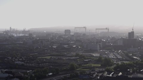 Aerial flyover of west Belfast from the countryside looking towards the city centre or center