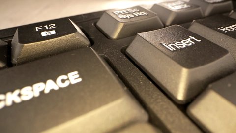 Backspace and Enter buttons with white arrow signs on computer black keyboard under bright light extreme closeup. Concept text message