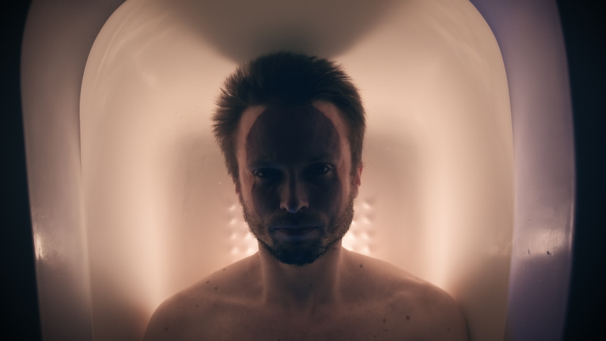 Adult male diving into water in the bath with color lighting