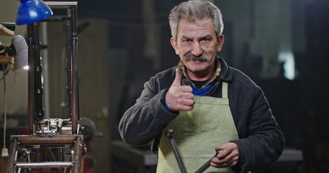 Senior master grandpa does the technical work and shows like a finger in the top that everything is fine and he is happy