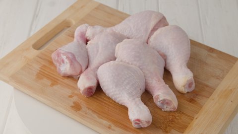 Fresh raw chicken drumsticks on a plate rotating.  raw chicken legs on a dish. Cooking food concept. Chicken parts close up footage. Fresh meat. Raw chicken legs for cooking. 