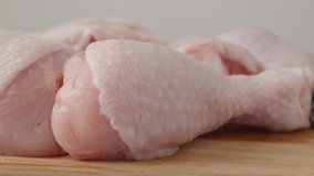 Fresh raw chicken drumsticks on a plate rotating.  raw chicken legs on a dish. Cooking food concept. Chicken parts close up footage. Fresh meat. Raw chicken legs for cooking. 