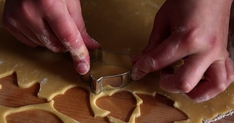 Making bell shape cookies from a dough with a cookie cutter tool by female hands home cooking slow motion