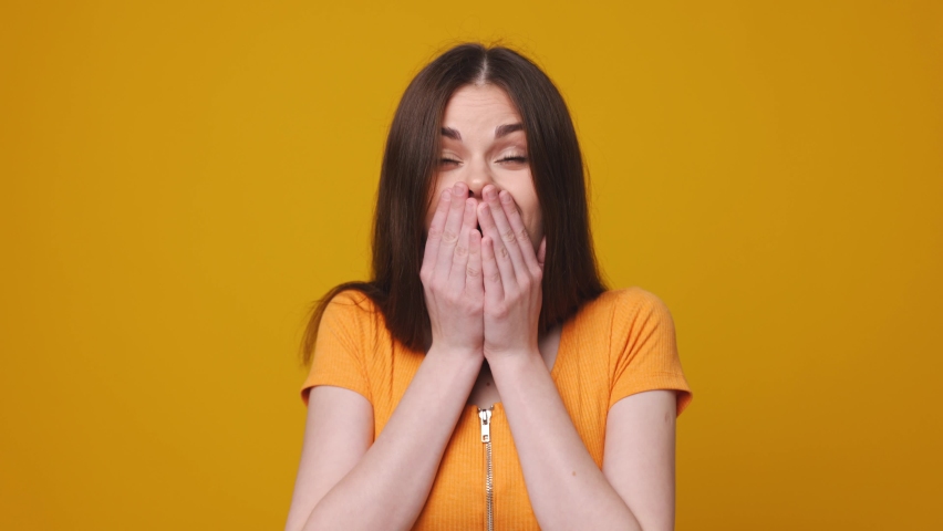 Woman emotion of surprise and happiness, jumping with delight on a yellow background | Shutterstock HD Video #1071270667