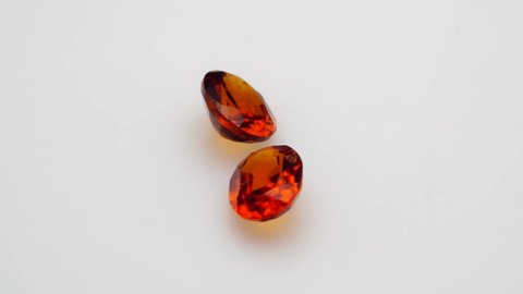 natural red hessonite garnet gemstone on the white background on the turning table