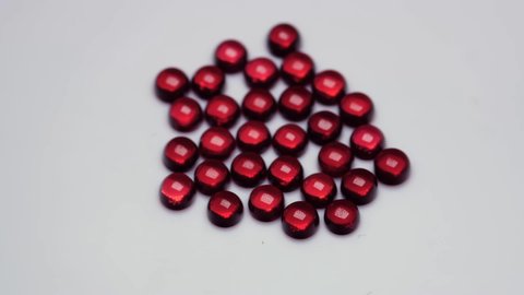 natural red garnet gemstone on the white background on the turning table