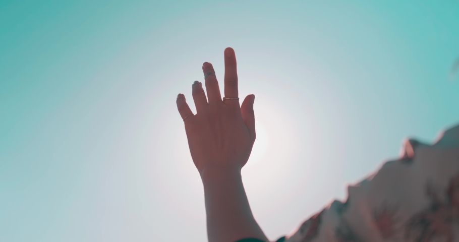 Waving hand to glare of sun flare in afternoon time, urban street. Woman's hand on balcony, sunbeams an gesture. Royalty-Free Stock Footage #1071283468