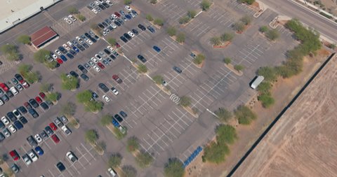 Aerial view a large number of cars different brands standing parking lot near the shopping center in parking divided by white dividing strips and sidewalks