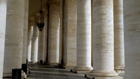 Walking along the path decorated with travertine columns of the Vatican square