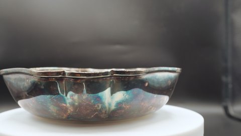 Close-up of silver antique bowl with rusty surface, vintage crockery of ancient special design from flee market, vintage collection of rusty items as a decorative tableware