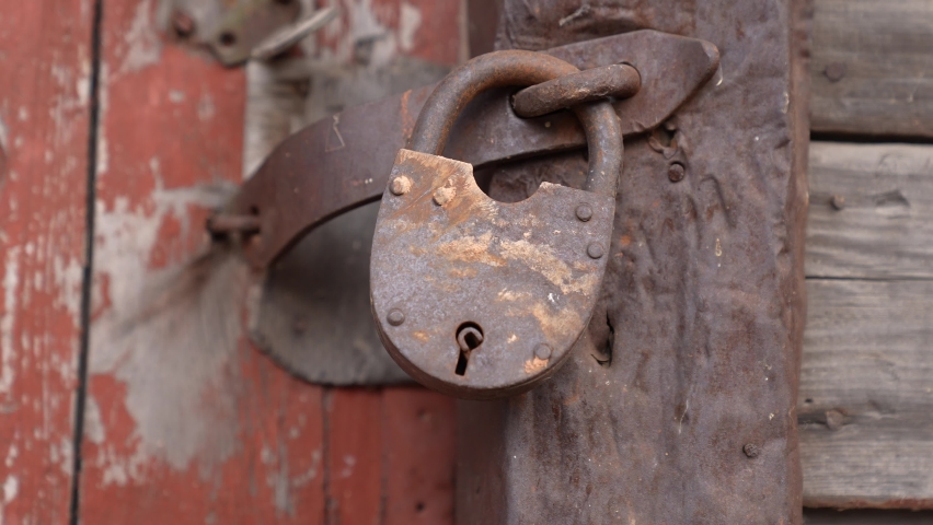 old iron lock on the garage. Vintage a closeup of red old iron lock garage. concept security conservation old house. closeup iron padlock. key password concept