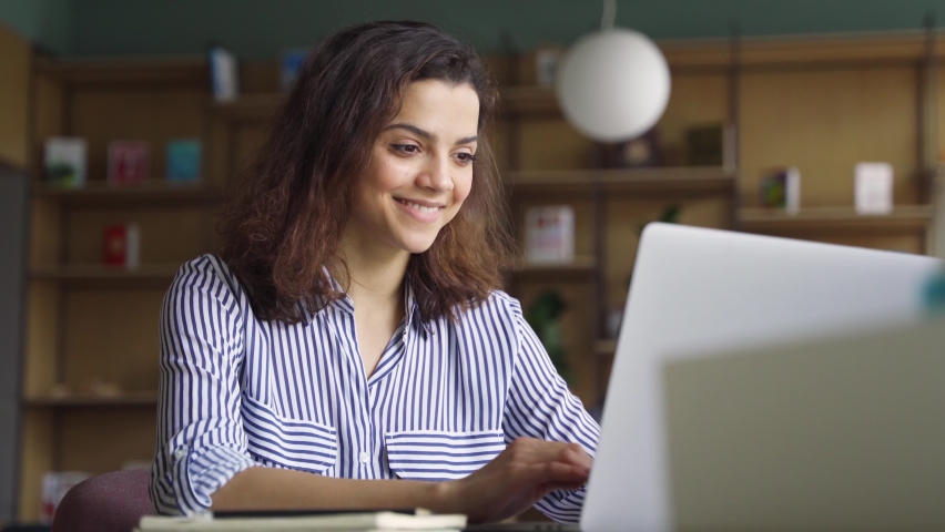 Happy latin girl college student using laptop computer watching distance learning seminar class, remote university webinar or having virtual classroom meeting, studying online in university campus. Royalty-Free Stock Footage #1071309490