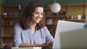 Happy latin girl college student using laptop computer watching distance learning seminar class, remote university webinar or having virtual classroom meeting, studying online in university campus. - Powered by Shutterstock - Get 15% off with code: PIKWIZARD15