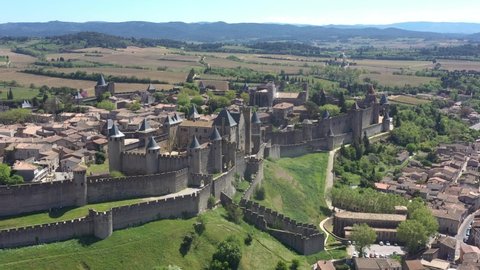 France, Carcassonne, fortified city, Comtal castle of the Counts of Carcassonne and the ramparts, a UNESCO World Heritage site. Backward drone aerial view