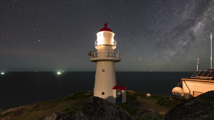 a beautiful cinematic timelapse of the milkyway rising over the ocean with the lighthouse in the foreground at Double Island point. Shot from tripod with wide angle lens
