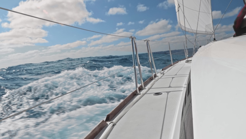 Breathtaking view of ocea water near yacht board. Water splashes making white foam. Yacht sailing in ocean.