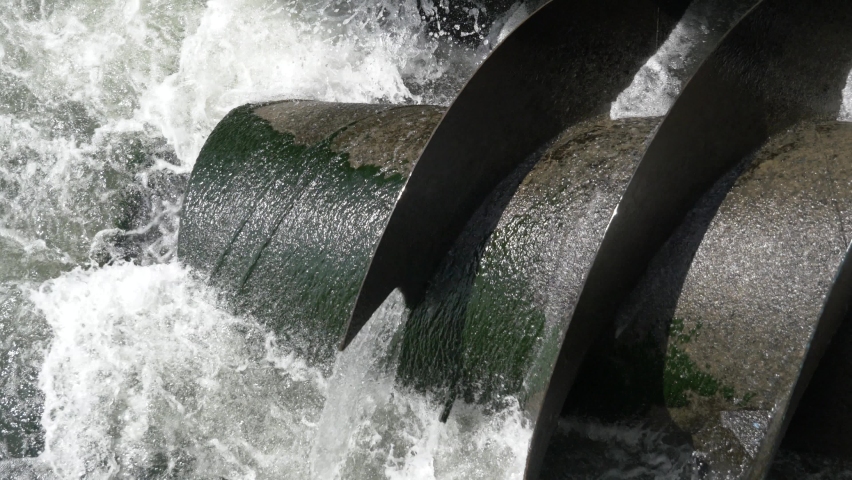 Powerfull metal hydro water turbine screw on river. This spiral is generating clean renewable energy electricity. Nothing but a hydroelectric. | Shutterstock HD Video #1071332644