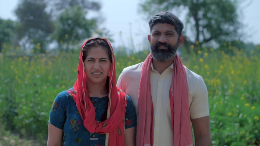 Indian villagers happily showing their ink-marked fingers after casting a vote - Indian farmer couple. Medium shot of a village woman in Salwaar Kameez and man with an Angocha standing in their gre... Royalty-Free Stock Footage #1071343303