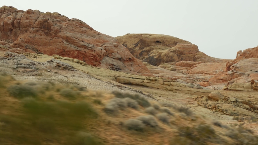 Road trip, driving auto in Valley of Fire, Las Vegas, Nevada, USA. Hitchhiking traveling in America, highway journey. Red alien rock formation, Mojave desert wilderness looks like Mars. View from car. | Shutterstock HD Video #1071344182
