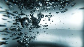 Water pouring into a glass close-up. Bubbles of water in a glass. 16x9 raw slow motion video. ProRes 422 HQ.