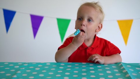 Little funny boy having fun and blowing party noisemaker. Gimbal motion