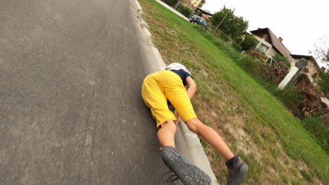 Caucasian boy riding a skateboard falling on an asphalt road