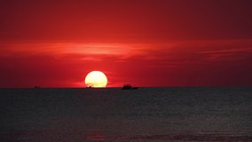Stock 4k video, Red sky sunsets over sea. Yellow sun and amazing sea. Summer sunset seascape, amazing sunrise over the tropical beach. The sun touches horizon, Light orange sunset in the ocean beach