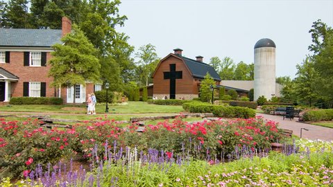 CHARLOTTE, NC - 2015: Billy Graham Library and Homeplace Museum in Charlotte NC Panning Over the Garden with People Walking to the Home