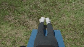 Playful sportsman extends leg behind him on fitness mat in the park