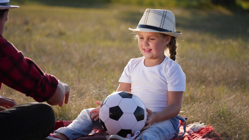 daughter with dad play ball in the park on vacation. happy family kid dream concept. daughter and father throw a ball to each other. dad lifestyle and daughter kid dream are resting in the park