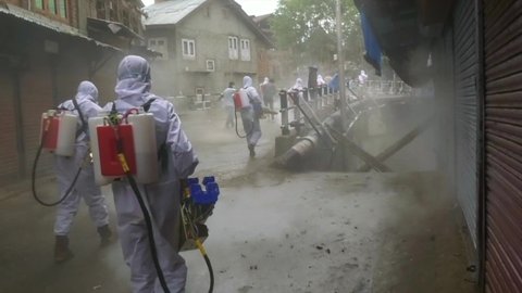 Men fumigation Frontline workers wearing white dress helping societies people to come out from covid-19 2nd phase