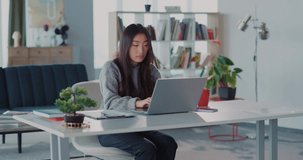 Excited young asian woman celebrating success at work, learning good news about employment, dancing inside her apartment. Business people concept.