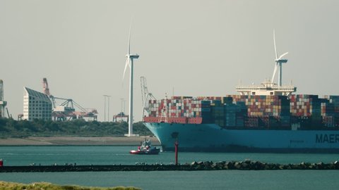 ROTTERDAM, THE NETHERLANDS - CIRCA 2019: Maersk huge container ship arriving at the Port of Rotterdam. View in the distance with strong heat haze atmospheric distortion
