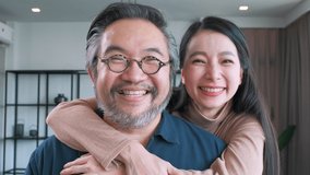 Closeup Middle-aged Asian couple smiling for the camera and looking each other. Family couple portrait - Powered by Shutterstock - Get 15% off with code: PIKWIZARD15