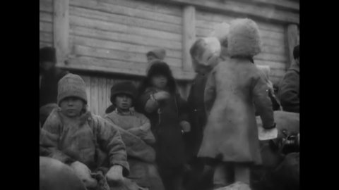 CIRCA 1920s - Starving Russian children congregate and adults fight over a piece of bread.