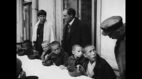 CIRCA 1920s - Will Kellogg and Elmer Burland feed starving Russian children.