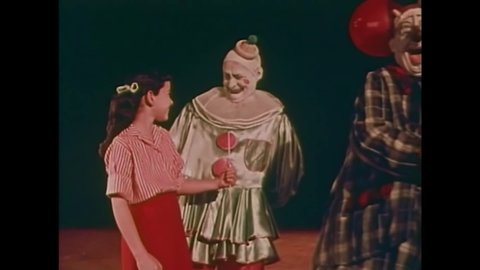 CIRCA 1958 - Clowns give children balloons at the circus, they see a fire eater, and animation is used to depict the process of a trapeze artist.