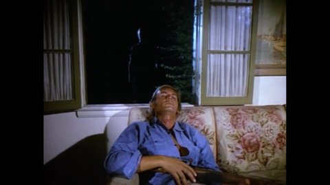 CIRCA 1971 - In this crime movie, an old man strangles a younger man through a window.