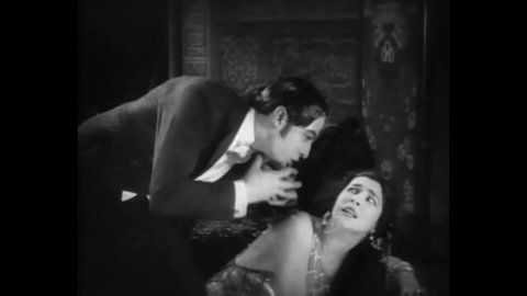 CIRCA 1922 - In this silent movie, a young woman throws herself at a man (Rudolph Valentino) who abuses her.