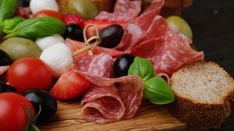 Traditional Italian appetizers ( antipasto ) : salami, bresaola, prosciutto, olives and mozzarella