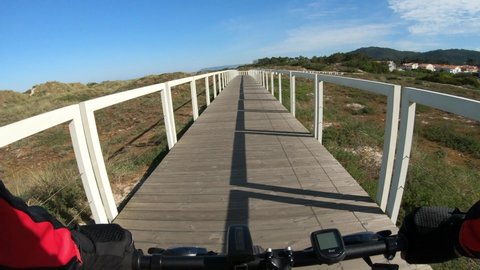 Esposende, Portugal, April 18, 2021:  POV SLOW MOTION of biker riding bike. First Person View of a man cycling in the Ecovia Litoral Norte (North Coast Ecoway), walking or cycling path.